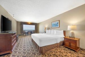 a hotel room with a large bed and a flat screen tv at Newport Oceanfront Inn in Newport