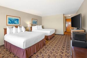 a hotel room with two beds and a flat screen tv at Newport Oceanfront Inn in Newport