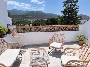 a group of chairs and tables on a balcony with mountains at Las Casillas de Laujar in Laujar de Andarax