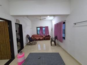 a living room with a couch and a table at Serene Farmhouse in Nimarkheri