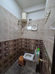 a bathroom with a toilet and a sink in it at Serene Farmhouse in Nimarkheri +13 photos