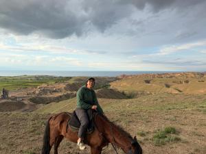 a man riding a horse on a hill at Rest House in Bokonbayevo