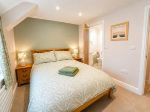 a bedroom with a large bed and a bathroom at Appletree Cottage in Wells