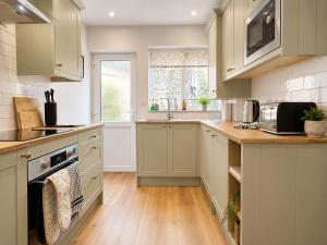 a kitchen with a sink and a stove top oven at Appletree Cottage in Wells