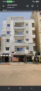 a large white building in front of a building at Awesome 3bhk apartment in Hyderabad