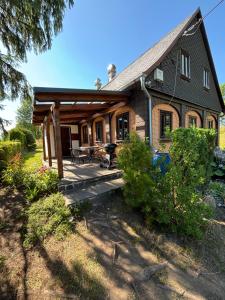 a large house with a porch and a deck at Roubenka Na vršku in Staré Křečany