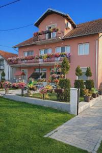 a pink house with flowers on a balcony at Apartman Pejović in Kladovo