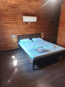 a bed in a room with a wooden wall at "La Aurel" Mahmudia in Mahmudia