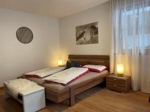two twin beds in a room with two lamps at Haus Priller in Sillian
