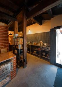 a large kitchen with a brick wall at ISEZI Historic Machiya in Shibata +32 photos