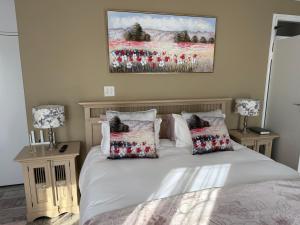 a bedroom with a bed with two lamps and a painting at Sweet Willa Bed and Breakfast in Roodepoort