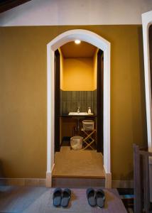 a hallway with a sink and two pairs of shoes at ISEZI Historic Machiya in Shibata