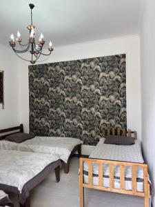 a room with two beds and a wall with a wallpaper at Dream Guest House in Bosteri