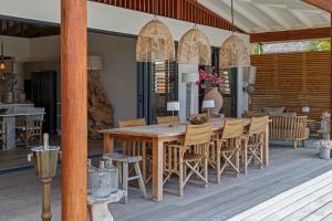 a wooden dining table and chairs on a deck at El Patrón, the villa in Jan Thiel