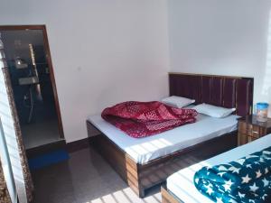 a bedroom with a bed with a wooden headboard at My Chopta Resort in Sari