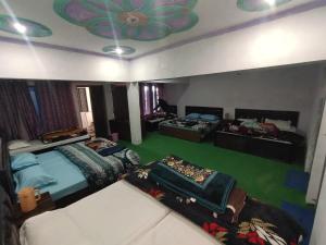 a bedroom with two beds and a ceiling with a flower on it at My Chopta Resort in Sari