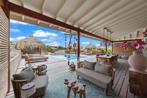 an outdoor patio with a couch and a pool at El Patrón, the villa in Jan Thiel