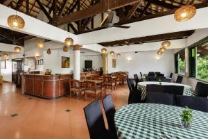 a restaurant with tables and chairs and a bar at Sunday Residence Inn Cherating in Cherating