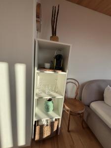 a white book shelf in a living room next to a couch at Panoramazimmer im Bregenzerwald in Schwarzenberg