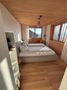 a bedroom with a bed and a large window at Panoramazimmer im Bregenzerwald in Schwarzenberg