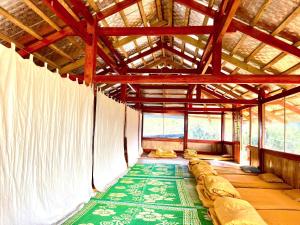 an inside view of a large room with a green rug at Homstay A Lệnh in Sơn La