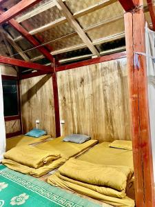 a room with two bunk beds in a wooden wall at Homstay A Lệnh in Sơn La