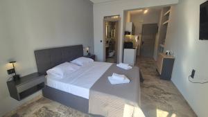 a bedroom with a large bed with two towels on it at Wide shore Apt in Kamári