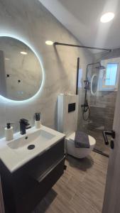 a bathroom with a sink and a toilet and a mirror at Wide shore Apt in Kamári