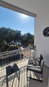 a balcony with a bed and a table and a view at Wide shore Apt in Kamári