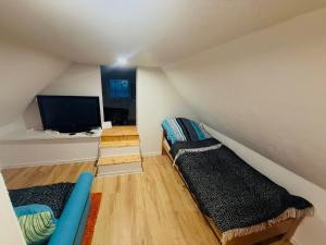 a attic room with two beds and a flat screen tv at Chalúpka pod hviezdami in Uličské Krivé