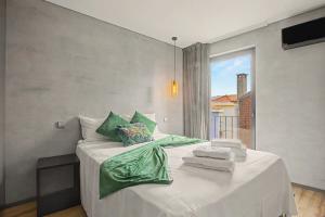 a bedroom with a large white bed with a window at Apartamento do Laço in Aveiro