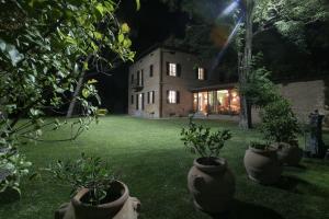 una casa con macetas en un patio por la noche en Relais Montemaggiore, en Bettolle