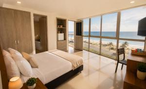 a bedroom with a bed and a view of the beach at Hotel Summer Frente Al Mar in Cartagena de Indias