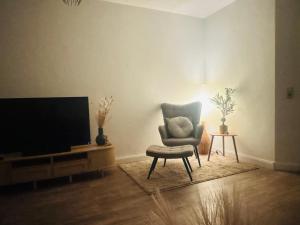 a living room with a chair and a television at Haus David in Erfurt