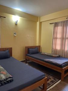 a room with two beds and a window at Lakecity Apartment in Pokhara
