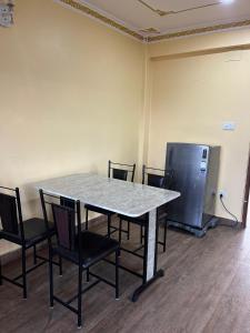 an empty room with a table and chairs and a refrigerator at Lakecity Apartment in Pokhara