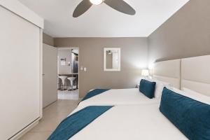 a bedroom with a large bed with a ceiling fan at Modern Ocean View Apartment in Cape Town