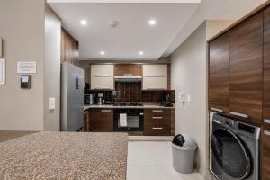 a kitchen with wooden cabinets and a washer at Modern Ocean View Apartment in Cape Town