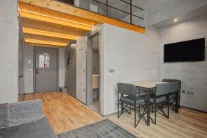 a dining room with a table and chairs and a television at Apartamento do Laço in Aveiro