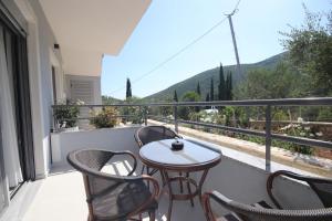 a balcony with a table and chairs and a view at Avli Rooms in Himare