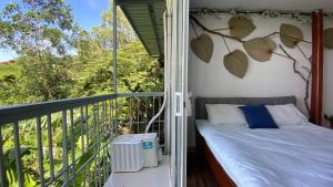 a porch with a bed on a balcony at T - Bona Homestay in Xã Thang Tam