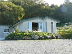 a small house with flowers in front of it at Roberts’ Cottage in Westport