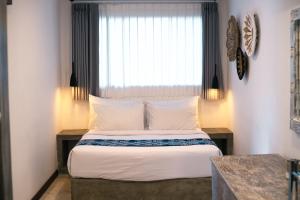 a bedroom with a large bed with a window at Alami Apartment Seminyak in Seminyak