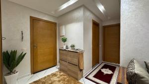 a room with a hallway with a wooden door at Airport's Layover Apartment in Nouaceur
