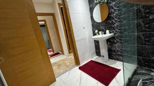 a bathroom with a sink and a mirror at Airport's Layover Apartment in Nouaceur
