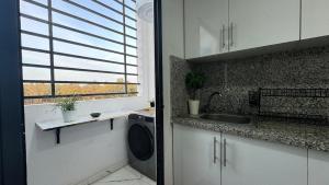 a kitchen with a sink and a washing machine at Airport's Layover Apartment in Nouaceur +10 photos