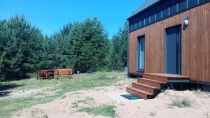a wooden cabin with a bench next to it at Domek letniskowy Płaska in Płaska