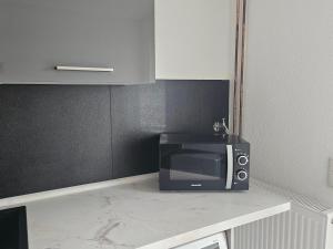a microwave sitting on a counter in a kitchen at RUWERA SONNENHÜGEL - Moderne Ferienwohnung - eigener Eingang, Garten und Terrasse in Trier