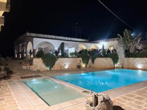 a swimming pool in front of a building at night at Casolare Lodedo in Ceglie Messapica +91 photos