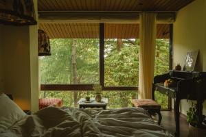 a bedroom with a bed and a large window at MONKEY RESORT in McLeod Ganj